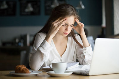 nervous stressed female student feeling headache studying cafe